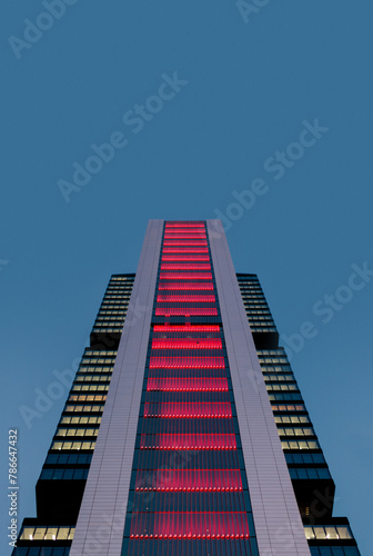 Illuminated modern skyscraper against twilight sky