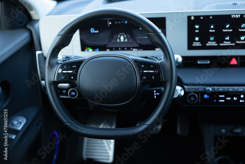 Steering wheel of electric vehicle, interior, cockpit, electric buttons. Autonomous car. Driverless car. Self-driving vehicle. Empty cockpit electric vehicle, Head Up Display and digital speedometer