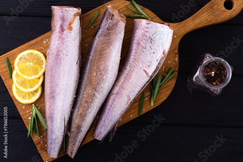 Raw hake on wooden background