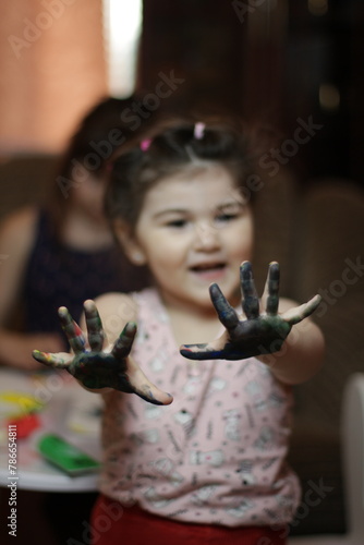 Girls playing with painting with their hands