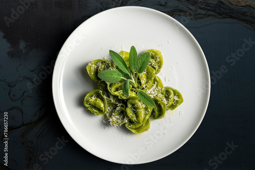 Dinner plate of green ravioli with sage and parmesan