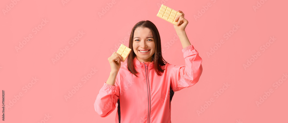 Young woman with white chocolate bars on pink background