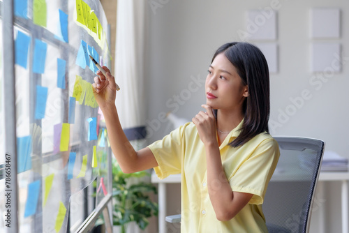 Businesswoman writing on sticky notes for brainstorming session in office. Creative planning and organization concept Free Download Businesswoman writing on sticky notes for brainstorming session in office. Creative planning and organization concept - GFXLoad