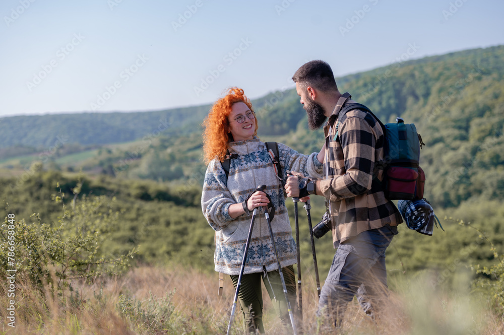 A beautiful and cheerful couple is hiking in the mountains, enjoying nature and each other's company A beautiful and cheerful couple is hiking in the mountains, enjoying nature and each other's company