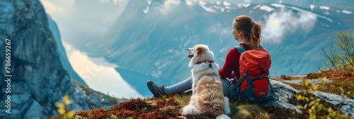 Female traveler with dog looking at fjord from mountain. Woman on a hiking trip. Active travel lifestyle. Winter tourism, adventure, vacation freedom. Design for banner, header with copy space