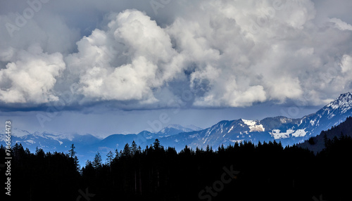 Dunkle Wolken über den Bergen und einem Wald - eine unheimliche Stimmung