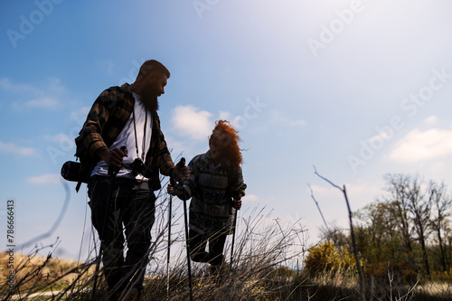 A beautiful and cheerful couple is hiking in the mountains, enjoying nature and each other's company