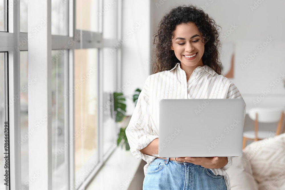 Young African-American woman using laptop at home Young African-American woman using laptop at home