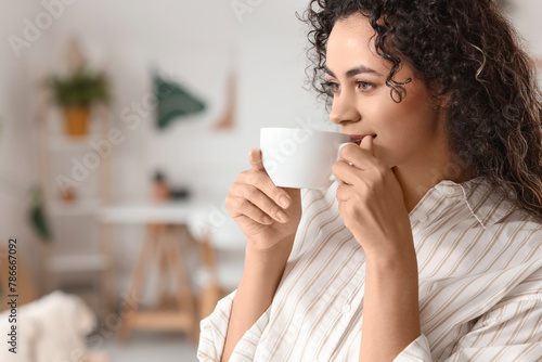 Young African-American woman drinking coffee at home, closeup