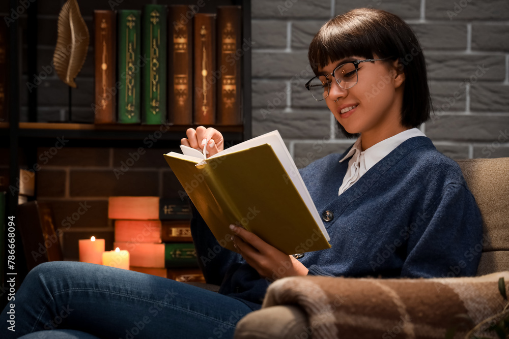 Young woman reading book in library at night Young woman reading book in library at night