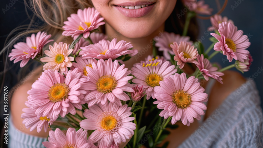 Of a beautiful bouquet of fresh pink daisies in bloom held by a smiling person in a light colored top. Of a beautiful bouquet of fresh pink daisies in bloom held by a smiling person in a light colored top.
