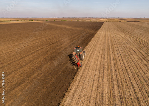 Aerial view of a tractor plowing rich farmland at the break of dawn