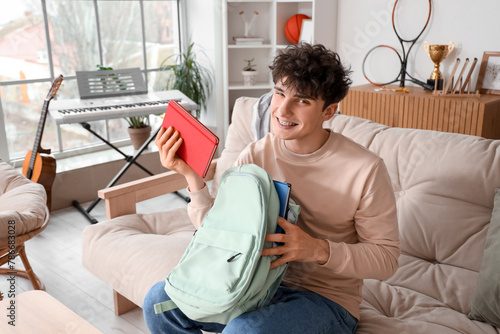 Male student packing backpa...