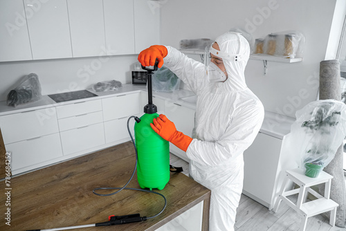 Male worker with disinfecta...