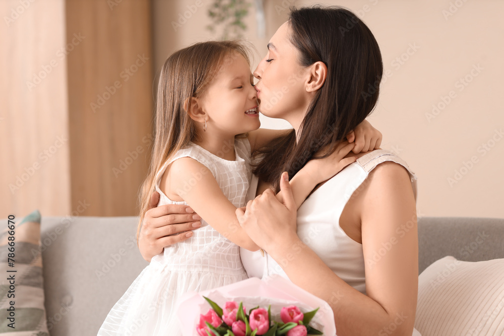 Happy mother kissing her cute little daughter at home on holiday Happy mother kissing her cute little daughter at home on holiday
