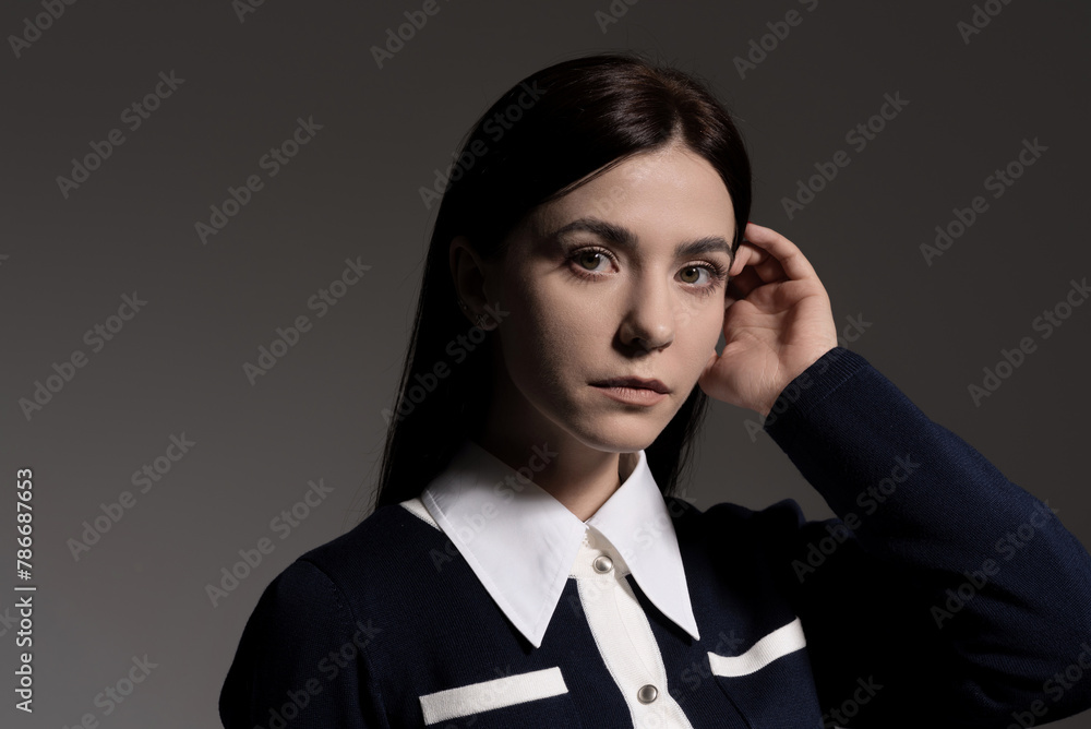 Portrait of attractive caucasian young brunette woman in school uniform in studio. Elegant woman posing. Pretty stylish model. Beauty, Style, Fashion, Luxury Portrait of attractive caucasian young brunette woman in school uniform in studio. Elegant woman posing. Pretty stylish model. Beauty, Style, Fashion, Luxury
