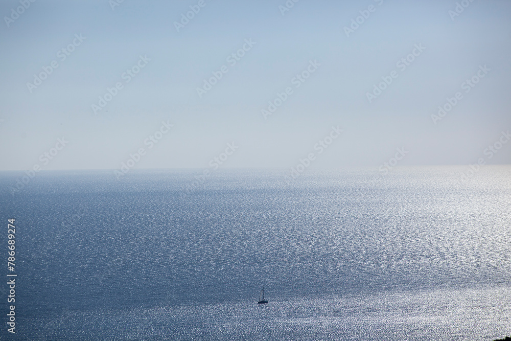 A small sailing boat sails on the sea surface of the Adriatic Sea. Balkans. View from above. Montenegro. Budva. Horizontal.