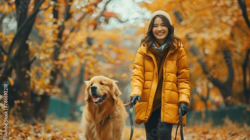 A relaxing golden retriever dog with a woman is walking together at park.