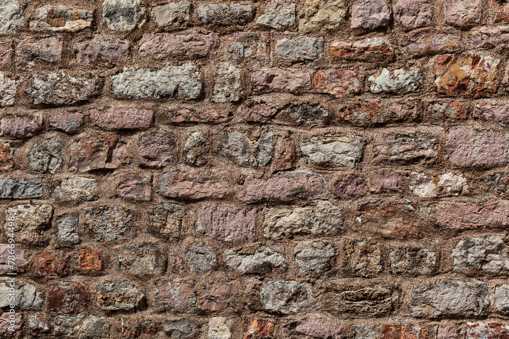 Stone texture of a wall in Montenegro. An ancient wall made of brown coloured stones. Background. Template. For design. Horizontal. Stone texture of a wall in Montenegro. An ancient wall made of brown coloured stones. Background. Template. For design. Horizontal.