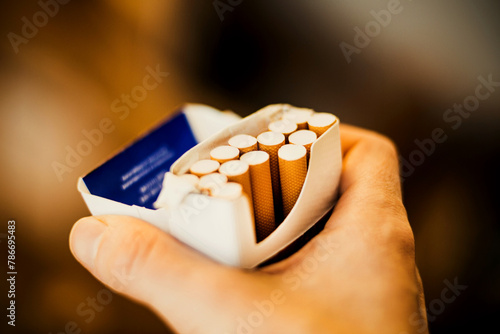A human holds an open pack of cigarettes in his hand. Smoking kills.