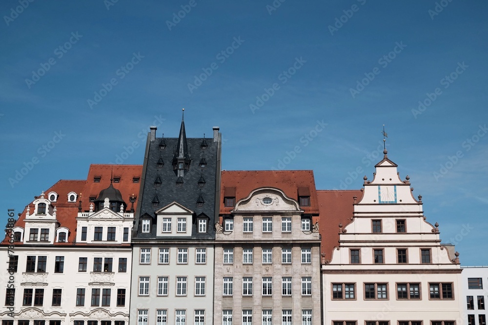 Schöne restaurierte Fassade alter Kaufmannshäuser mit Mansarde, Turm, Gaube, Giebel und Erker im Frühling bei blauem Himmel und Sonnenschein am Markt in der Innenstadt von Leipzig im Freistaat Sachsen Schöne restaurierte Fassade alter Kaufmannshäuser mit Mansarde, Turm, Gaube, Giebel und Erker im Frühling bei blauem Himmel und Sonnenschein am Markt in der Innenstadt von Leipzig im Freistaat Sachsen