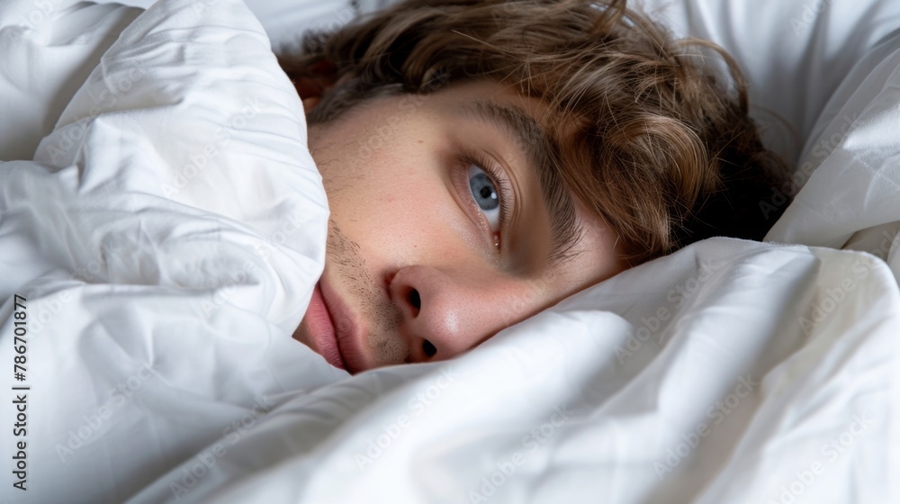 Young Man Peeking Out from Cozy White Bedding Young Man Peeking Out from Cozy White Bedding