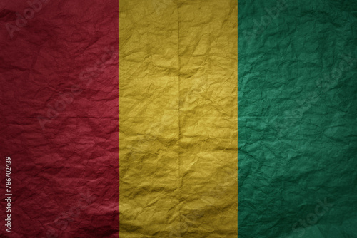 big national flag of guinea on a grunge old paper texture background