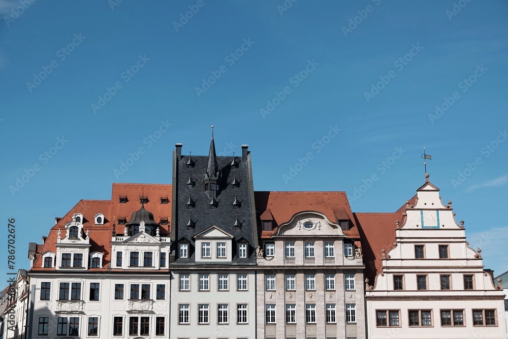 Schöne restaurierte Fassade alter Kaufmannshäuser mit Mansarde, Turm, Gaube, Giebel und Erker im Frühling bei blauem Himmel und Sonnenschein am Markt in der Innenstadt von Leipzig im Freistaat Sachsen Schöne restaurierte Fassade alter Kaufmannshäuser mit Mansarde, Turm, Gaube, Giebel und Erker im Frühling bei blauem Himmel und Sonnenschein am Markt in der Innenstadt von Leipzig im Freistaat Sachsen