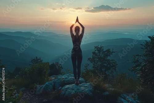 A woman is doing yoga on a mountain top photo