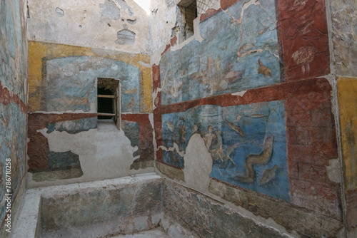 View from inside the ruins of ancient roman suburban baths with beautiful colored art on the wall in the destroyed city of Pompeii, Campania, Italy