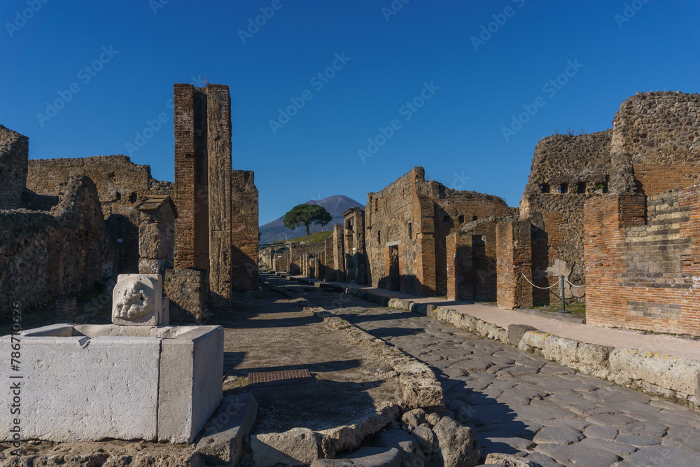 Roman street on a sunny day through the Ruins of Pompeii, Campania, Italy