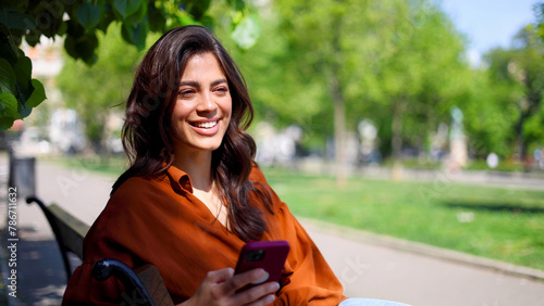 Beautiful Latin woman texting on smartphone outdoors