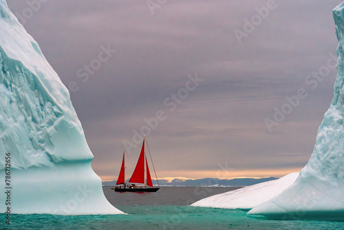 Red sailboat between two icebergs in Ilulissat Greenland photo