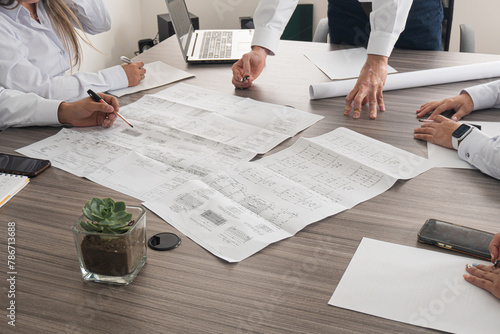 Engineering team reviewing blueprints. Person with vitiligo in a work environment. Business meeting and project planning at an engineering company. where professionals discuss projects and delivery 