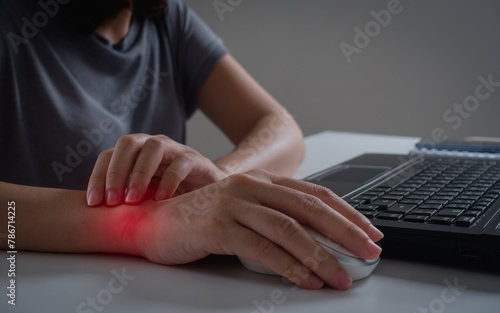 Tableau sur toile Young woman working in an office with carpal tunnel syndrome or wrist joint inflammation, massage on her hand and arm for relief pain from hard work for stiff, cramp symptom, carpal tunnel syndrome