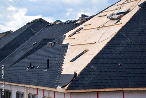 Tablou pe pânză Closeup installation of black roof shingles on new residential home