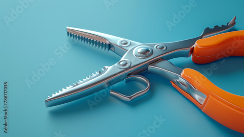 Modern kitchen tongs with orange handles isolated on a blue background. photo