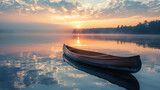 Sunrise over calm lake with canoe in foreground