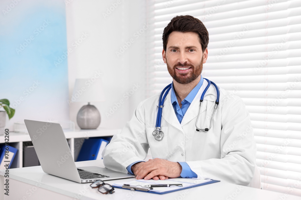 Medical consultant with stethoscope at table in clinic Medical consultant with stethoscope at table in clinic