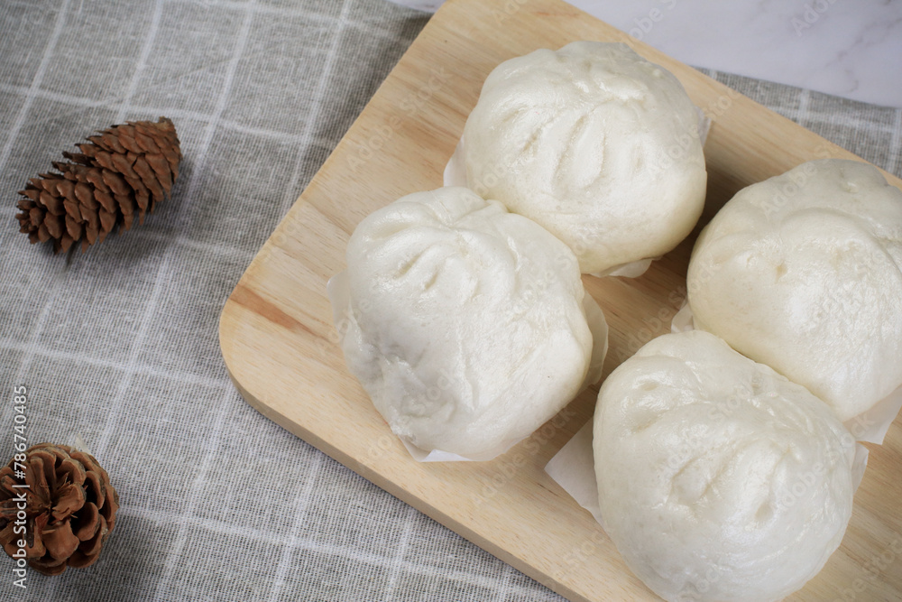 Steamed buns with minced pork on bamboo cutting board. Chinese food dim sum style. Breakfast Asian food. Steamed buns with minced pork on bamboo cutting board. Chinese food dim sum style. Breakfast Asian food.