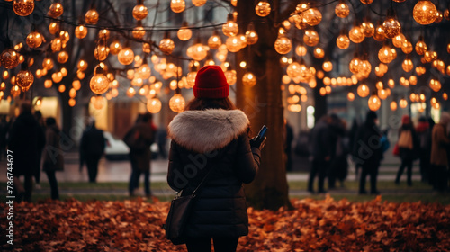 A person experiences a holiday outdoor scene with illuminated spherical lights and fall leaves.Applications related to winter activities.