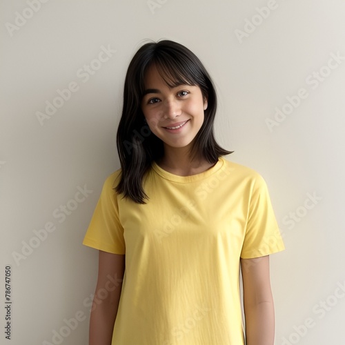young girl wearing a yellow shirtstanding in front of a wall