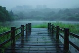 A wooden bridge over a body of water with a foggy background and a city in the distance on a foggy