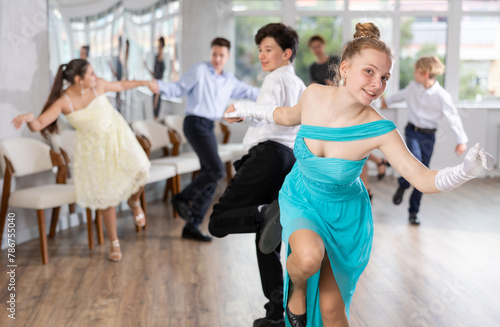 Group of festively dressed boys and girls dance a twist dance
