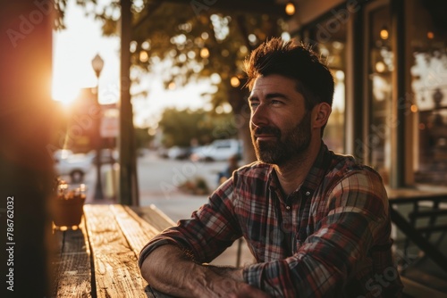 Handsome bearded man sitting in a pub with a cup of coffee