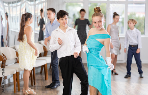 Girl in elegant dress posing while dancing in studio