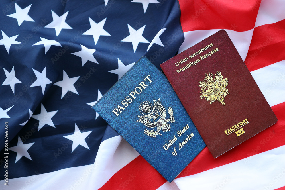 Naklejka premium Passport of France with US Passport on United States of America folded flag close up