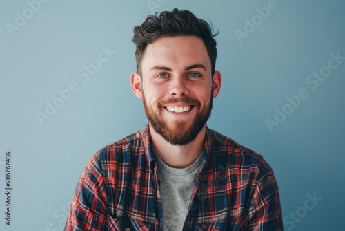 Portrait of a handsome bearded hipster man standing against grey background photo
