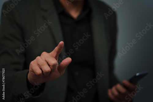 businessman is holding smartphone and pointing index finger