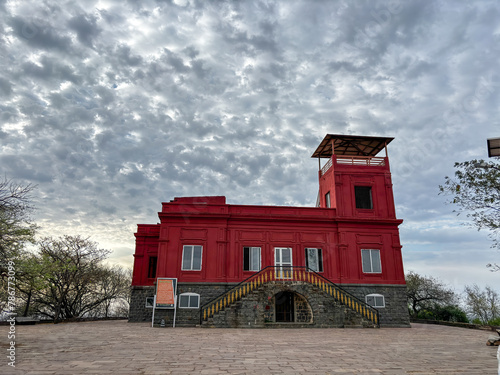 A red building with a sign on the front at Ralamandal, Indore, India. photo